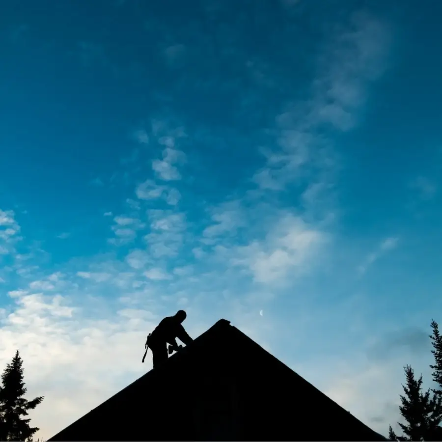 Roofing contractor working at roof ridge on residential home in Muskoka Ontario