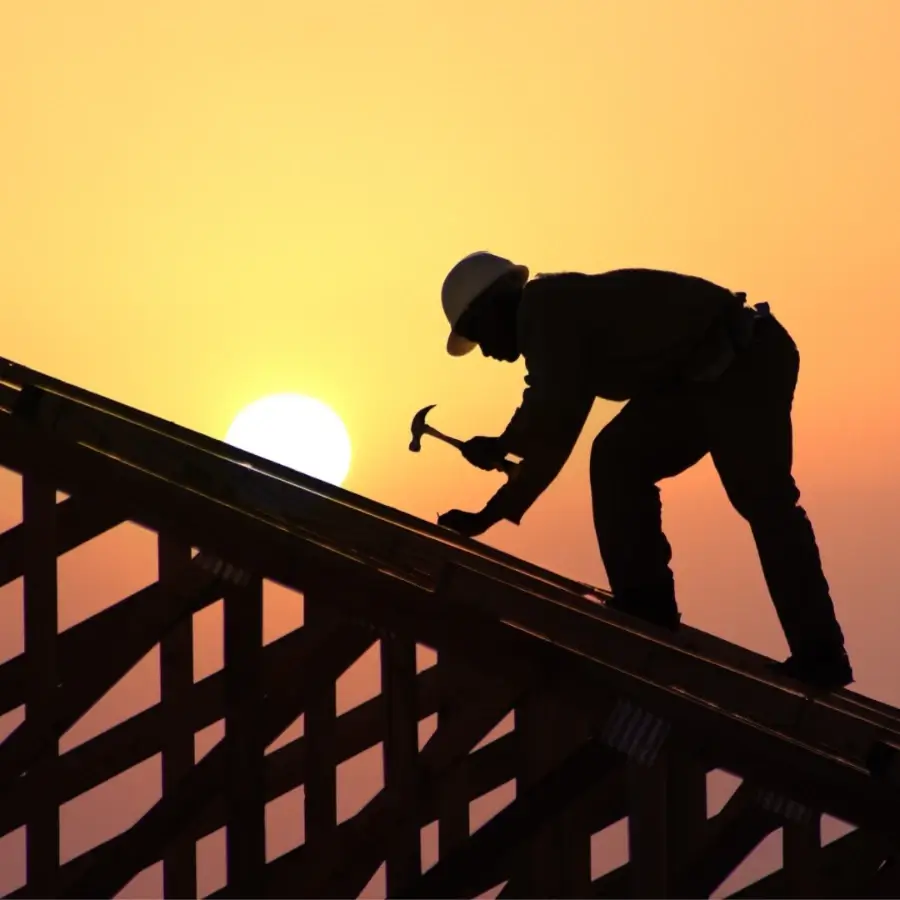 Roofing contractor working on wooden roof framing structure during residential roof construction in Muskoka