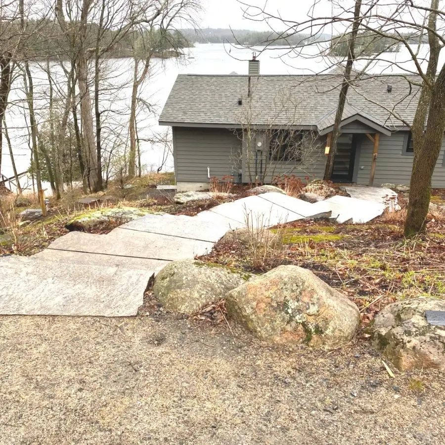 Lakefront cottage with asphalt shingle roof overlooking a Muskoka lake