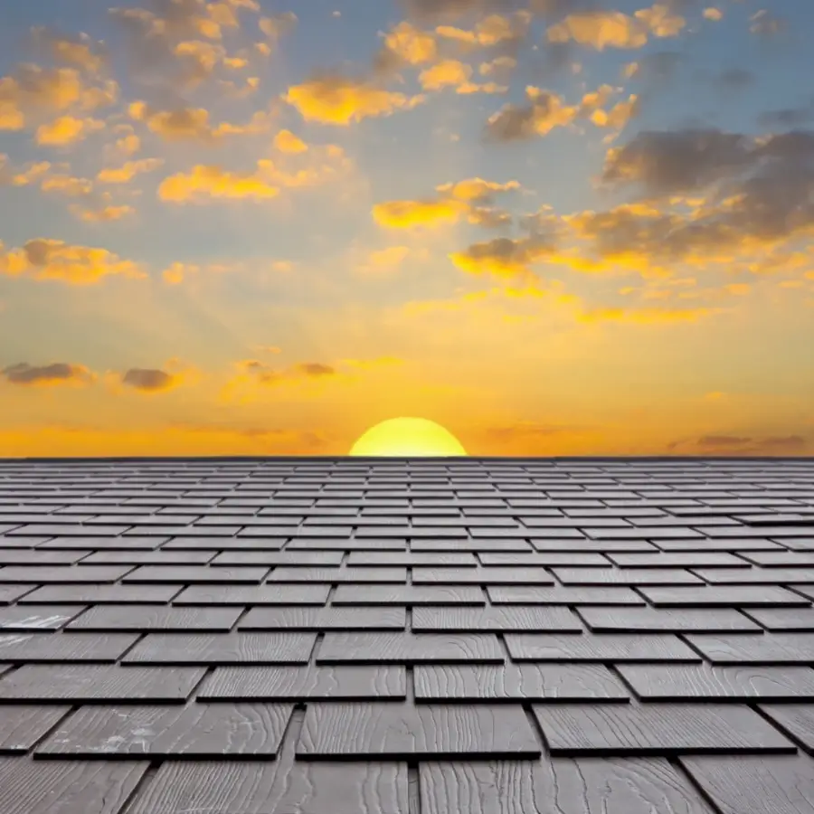 Close view of architectural asphalt shingles on a residential roof at sunset